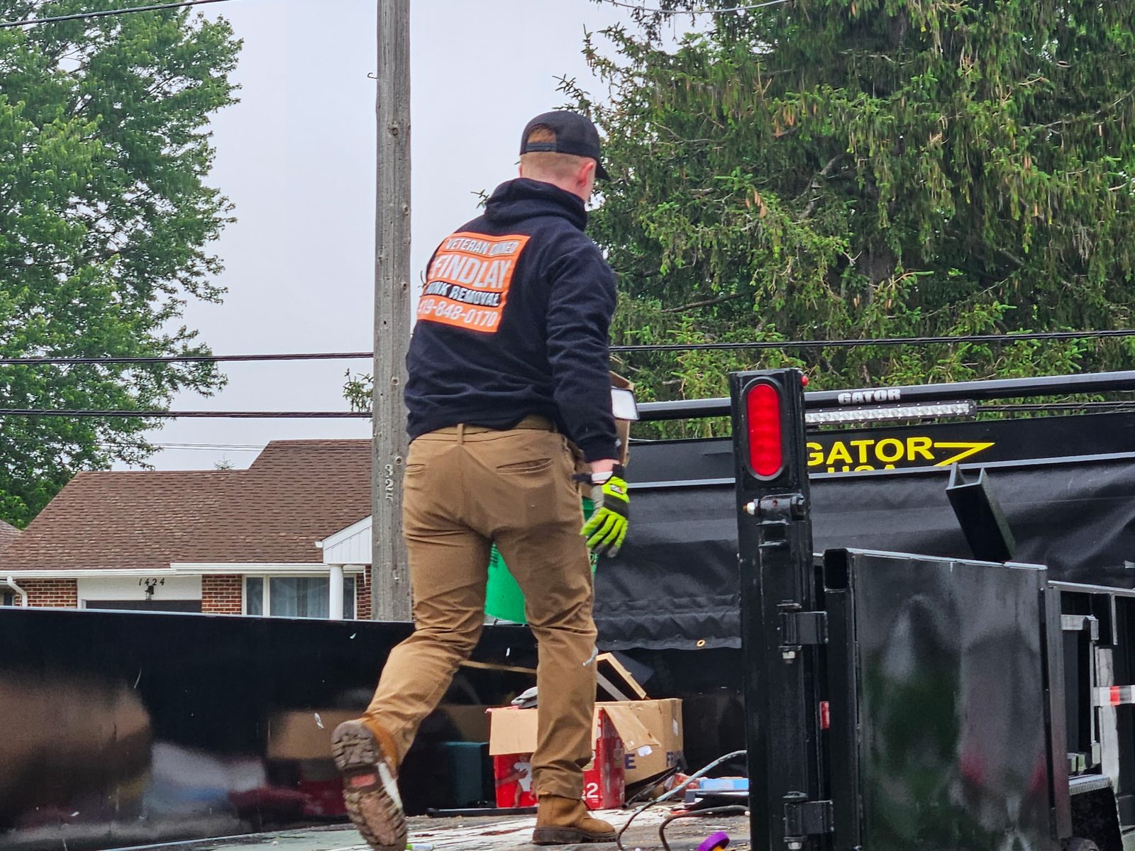 Findlay Junk Removal crew member working beside the company trailer